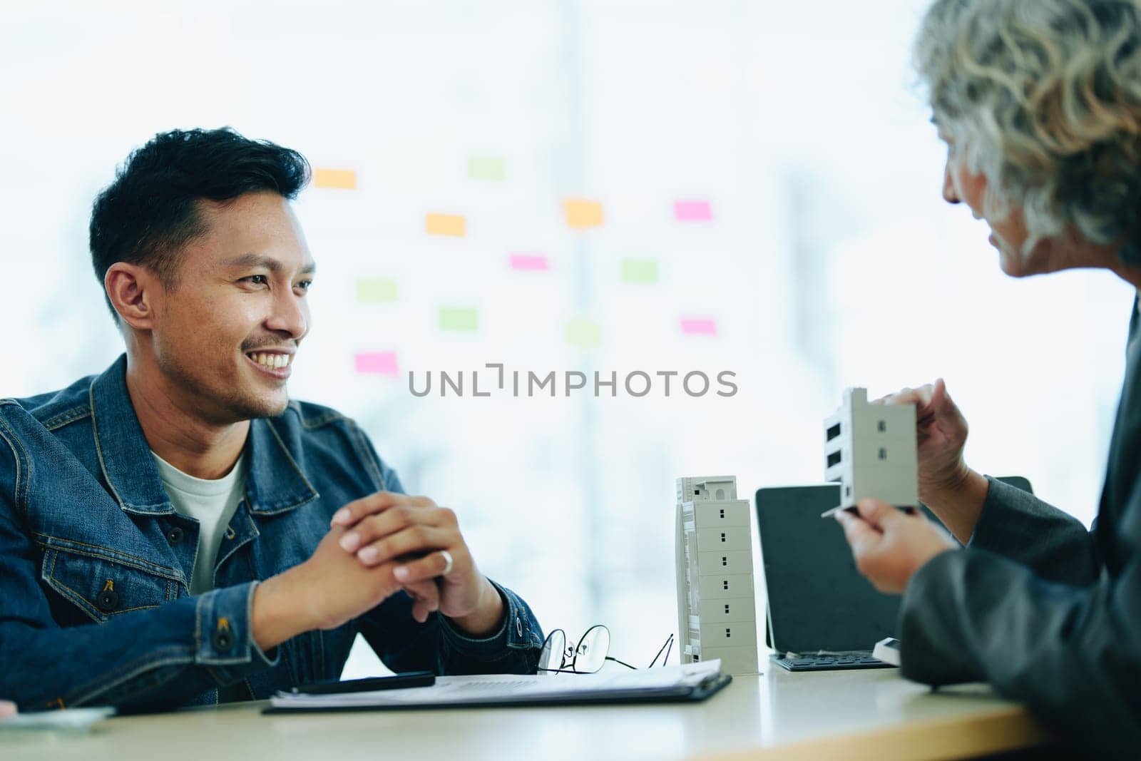 Guarantee Insurance Sign a contract, couple a smiling couple is signing a contract to invest in real estate with the Mortgage officer with the bank.