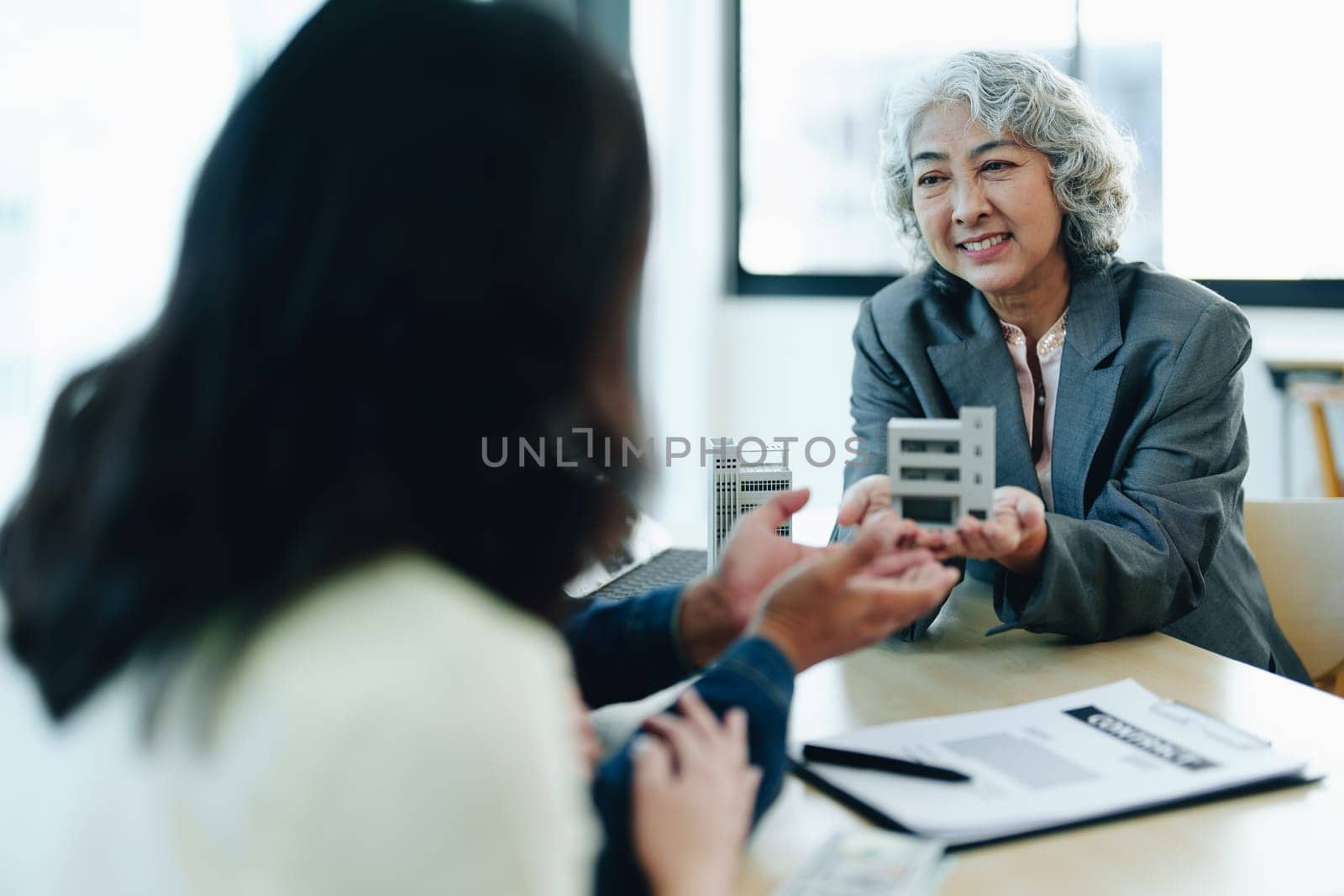 Guarantee Insurance Sign a contract, couple a smiling couple is signing a contract to invest in real estate with the Mortgage officer with the bank by Manastrong