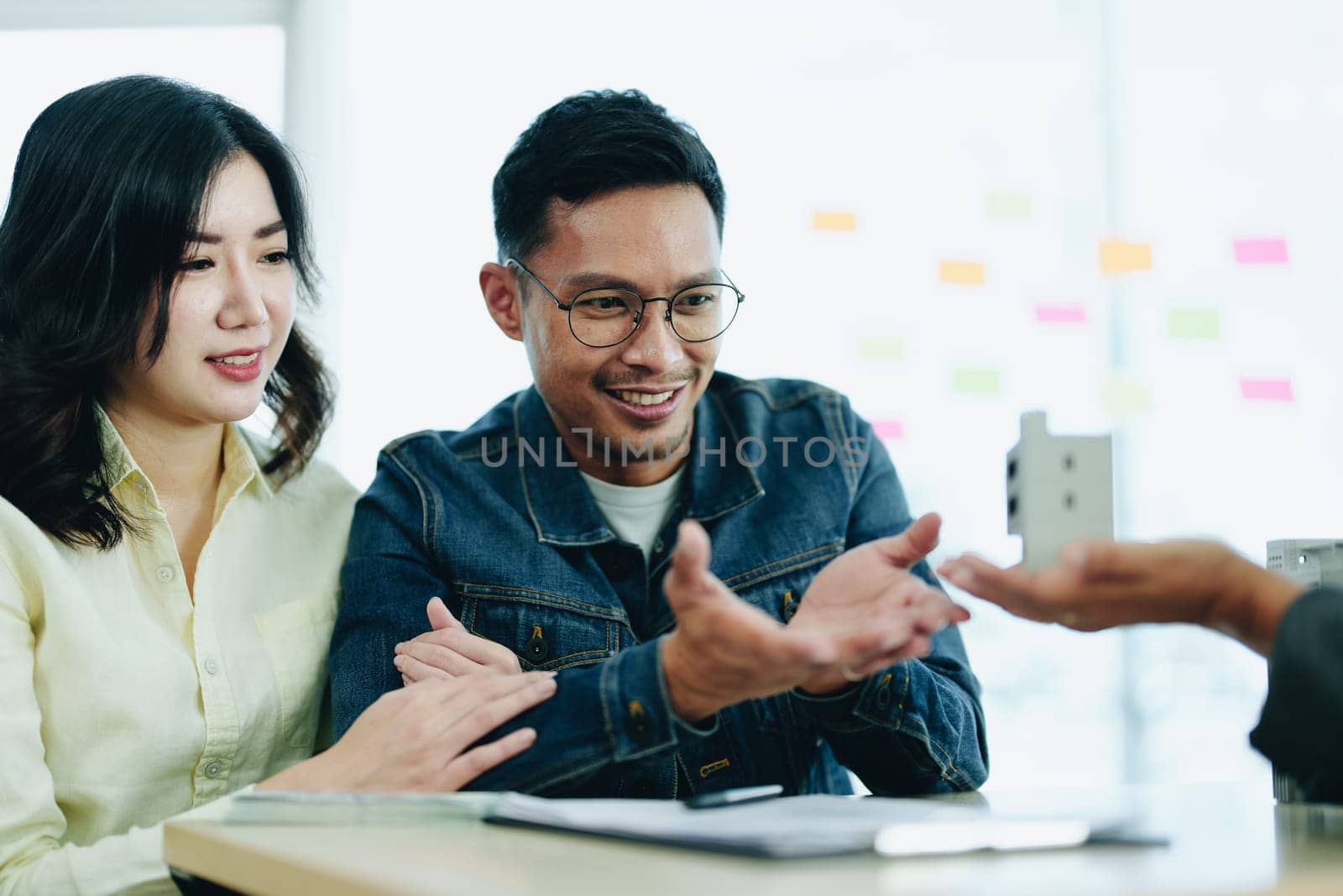 Guarantee Insurance Sign a contract, couple a smiling couple is signing a contract to invest in real estate with the Mortgage officer with the bank.