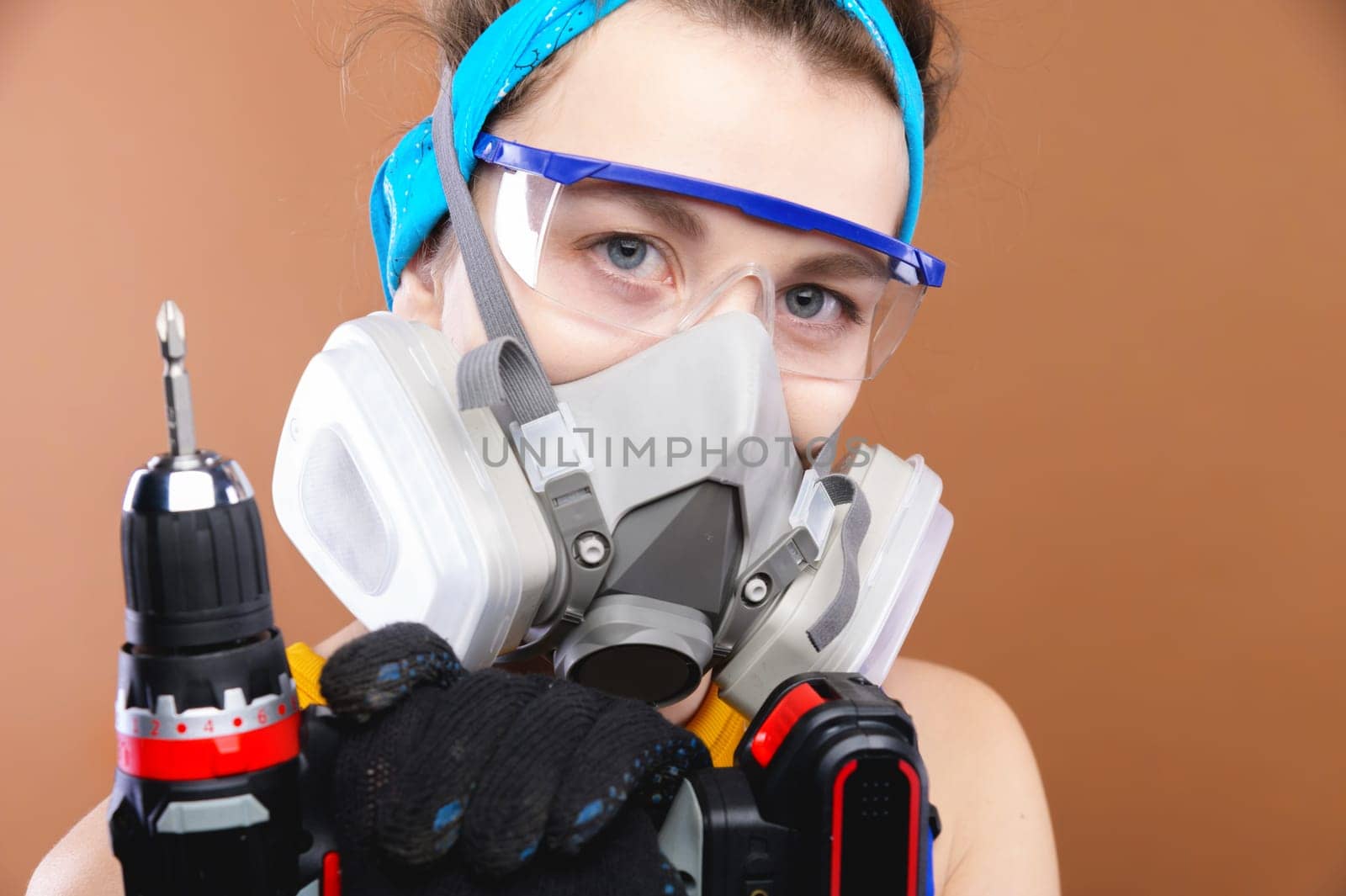 Portrait of a girl with an electric screwdriver. Woman worker with a tool in her hands. young technician concept.