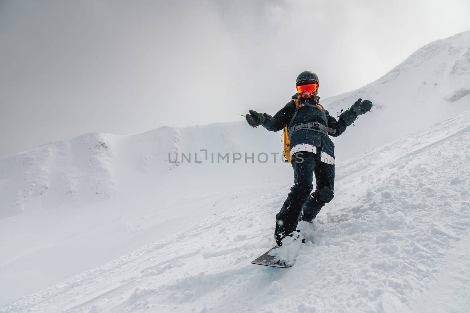snowboarder bent over and brakes on a freeride slope. Active man snowboarder rides on the slope. ski resort by yanik88