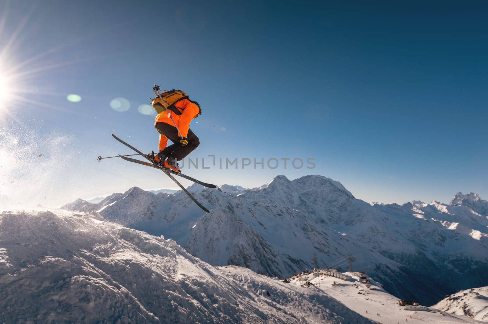 winter vacation at the ski resort. skier quickly fly in the air doing a stunt heli-skiing on the background of snow-capped mountains.