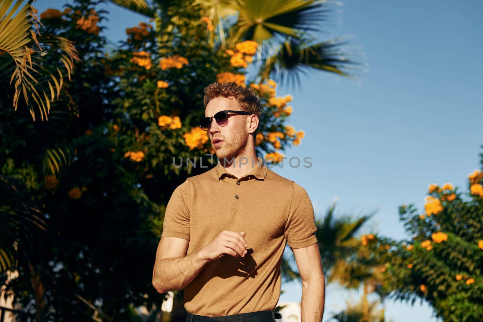 In sunglasses. Young man is outdoors at sunny daytime. Concept of vacation.
