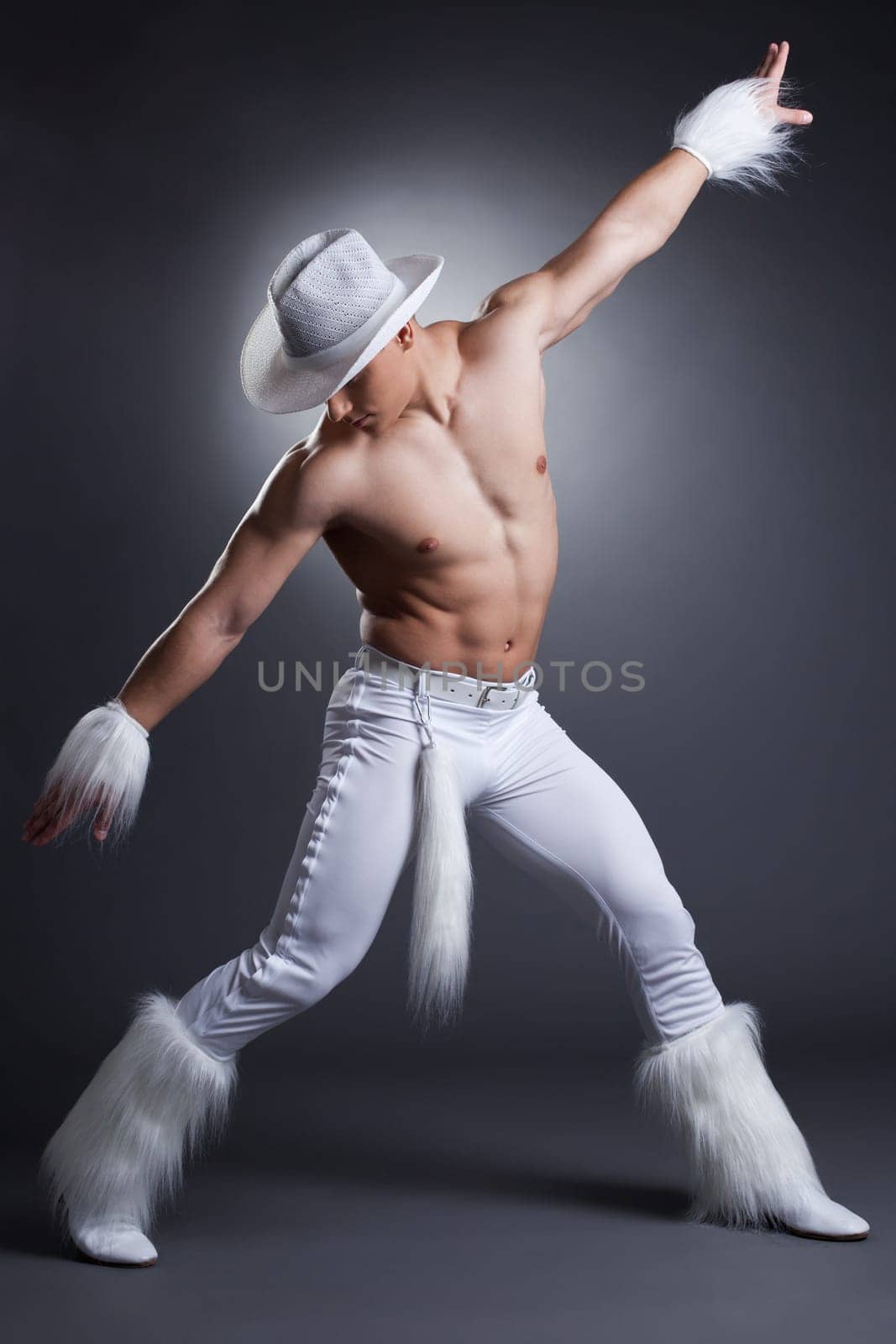 Sexy dancer in cowboy costume. Studio portrait