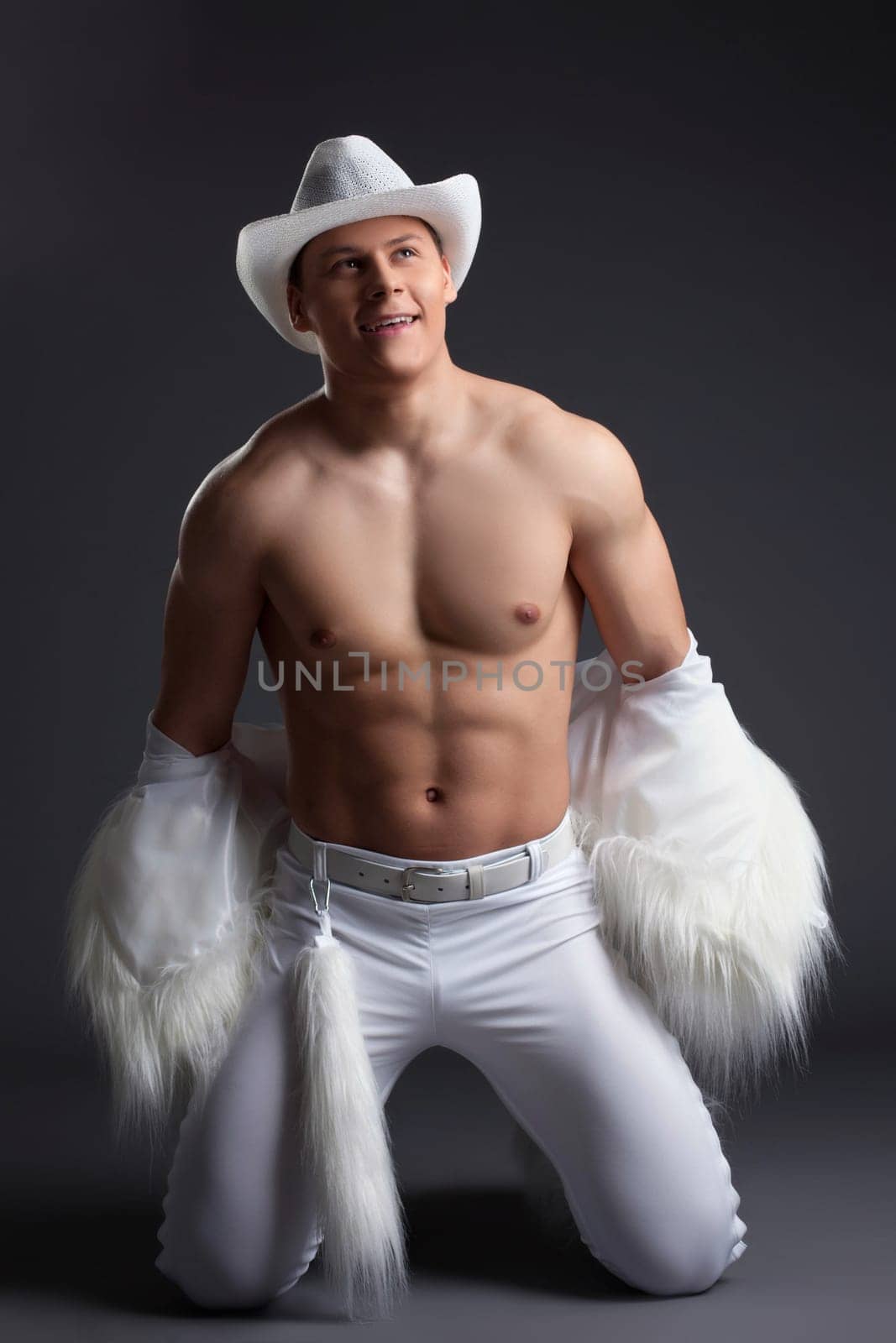 Dancer in white cowboy costume. Studio portrait