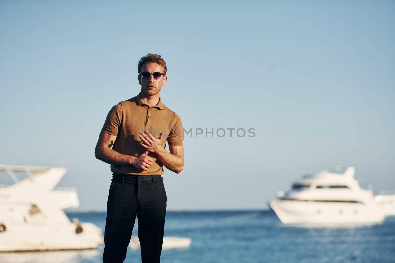 In sunglasses. Young man is outdoors at sunny daytime. Concept of vacation.