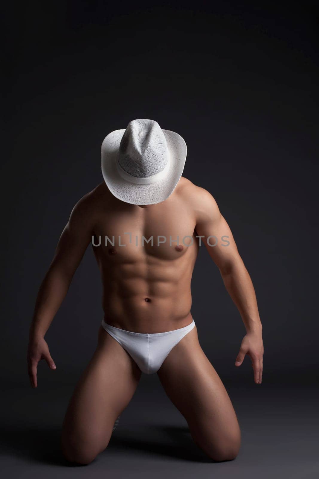 Sexy cowboy in white hat. Studio portrait