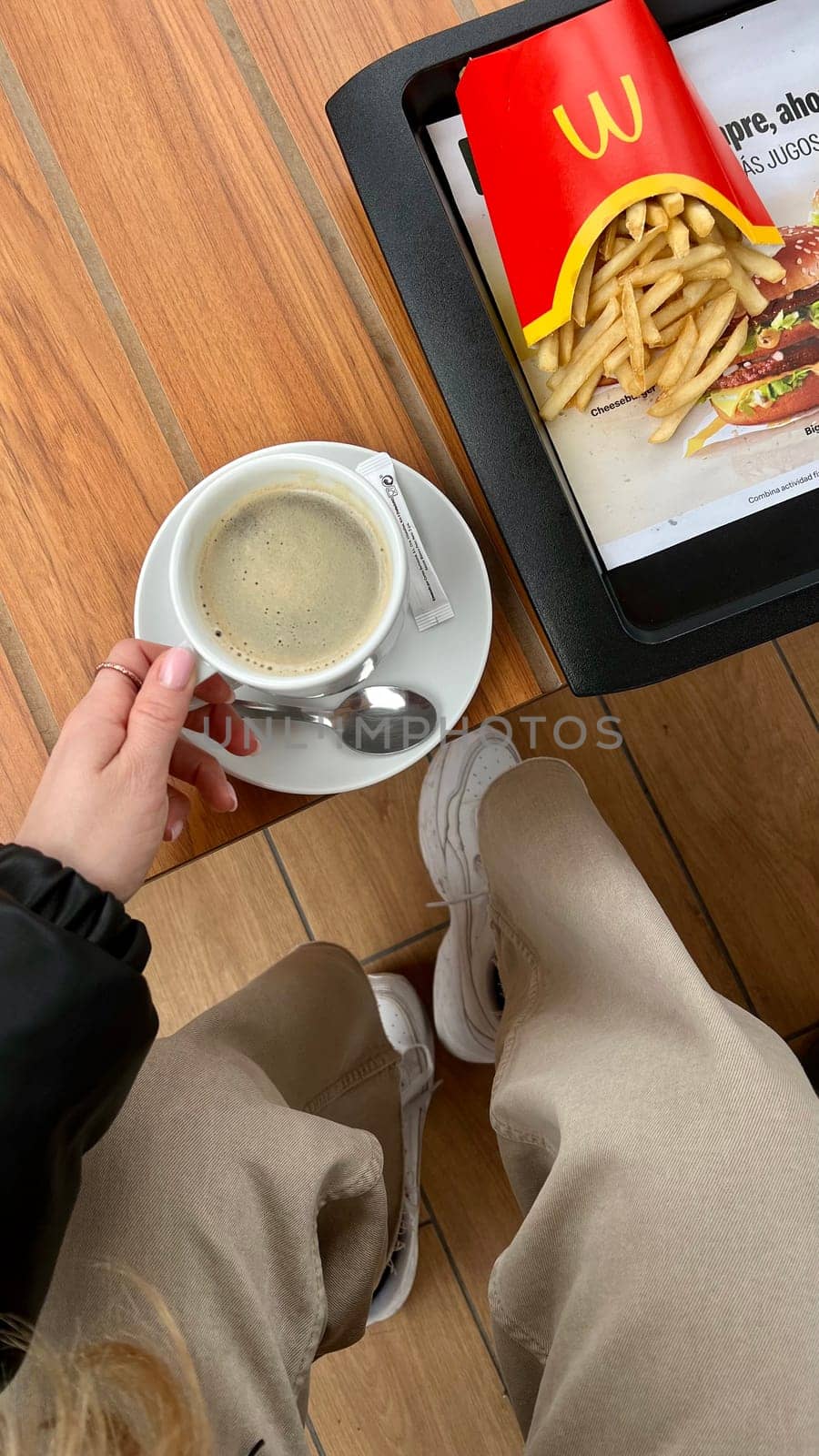 Americano coffee and potato french fries at McDonald's fast food restaurant. Lunch POV TOP view, close up, vertical, flatlay