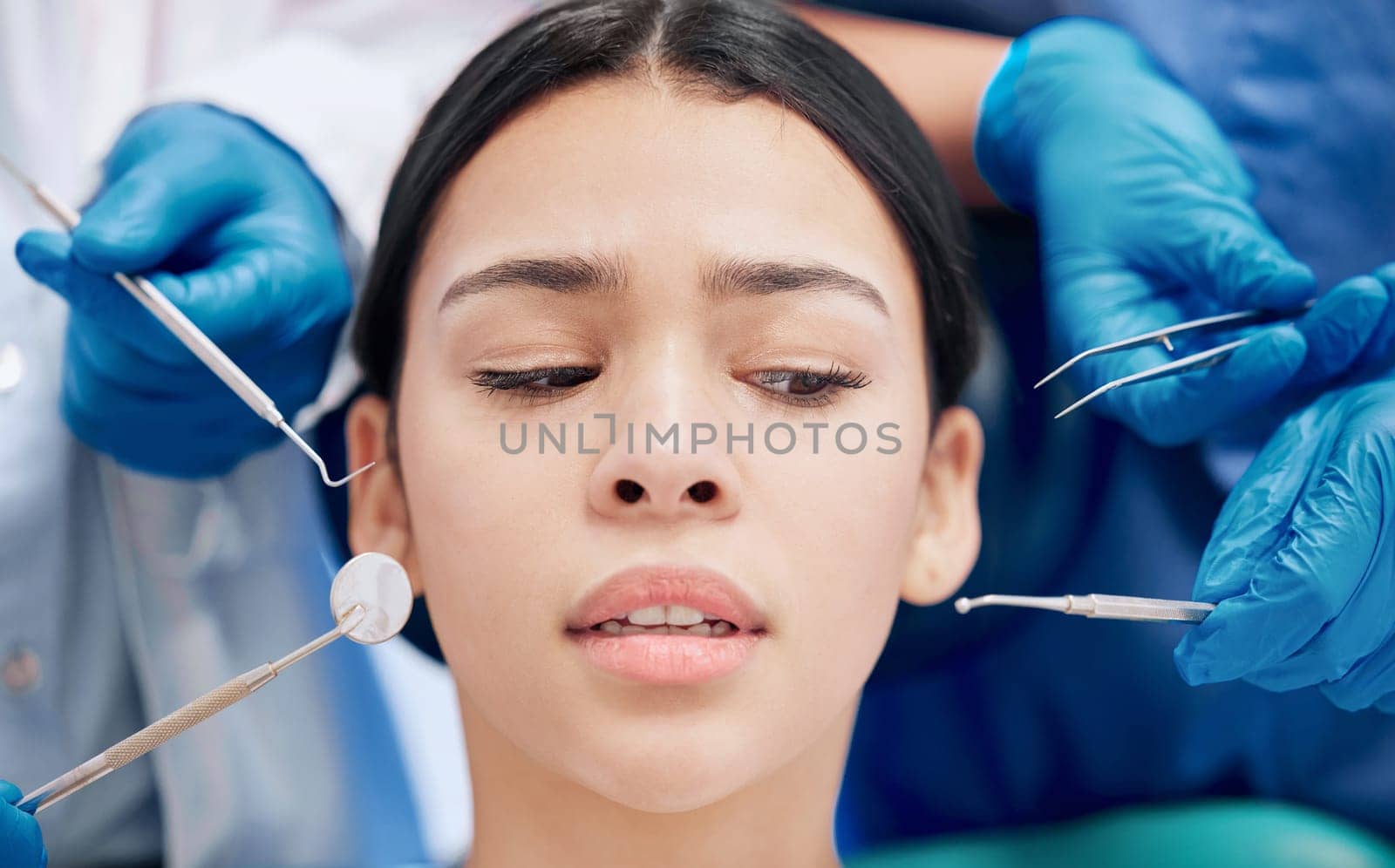 Oh no will this hurt. a young woman looking afraid at her dentists office