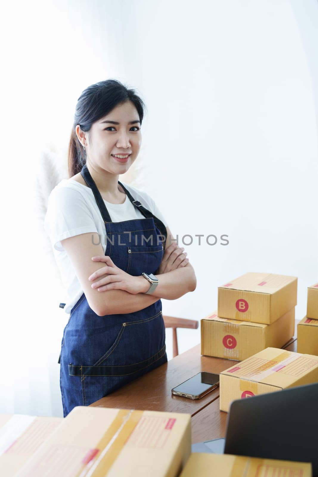 Starting small business entrepreneur of independent Asian woman smiling using tablet computer with cheerful success of online marketing package box items and SME delivery concept by Manastrong
