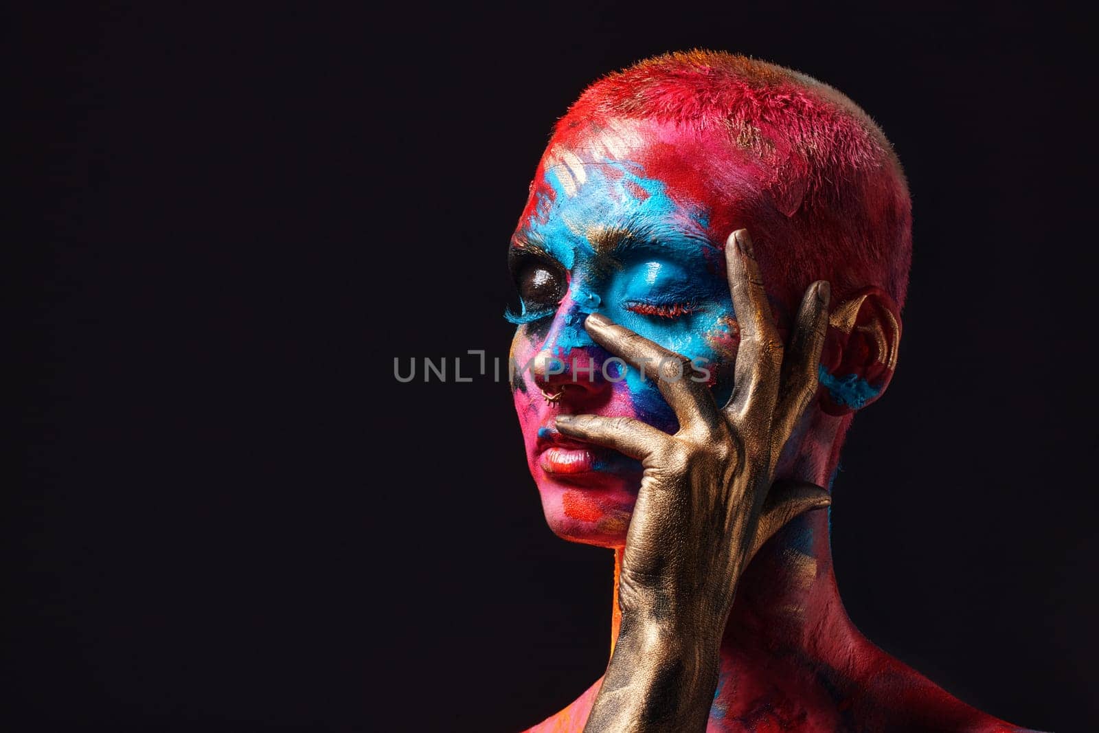 I dream in colour. an attractive young woman posing alone in the studio with paint on her face. by YuriArcurs