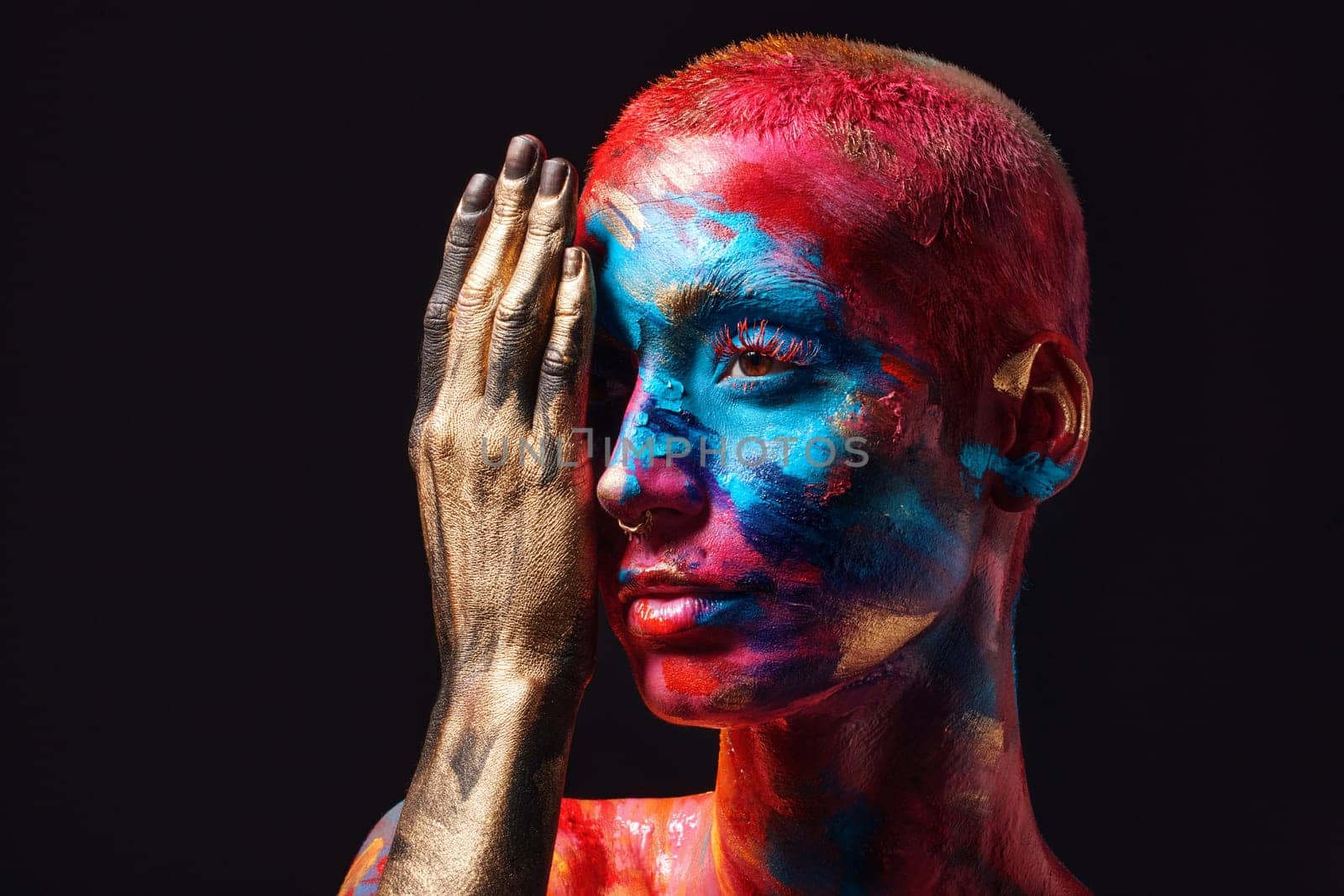 My colourful vision will never be altered. an attractive young woman posing alone in the studio with paint on her face