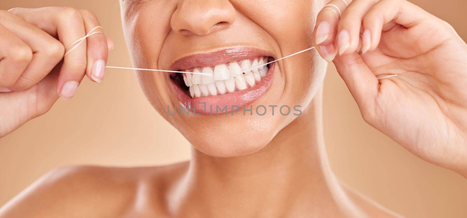Flossing, smile and a woman with dental care for teeth isolated on a studio background. Happy, healthcare and the mouth of a girl with a routine oral hygiene cleaning, treatment and tooth floss by YuriArcurs