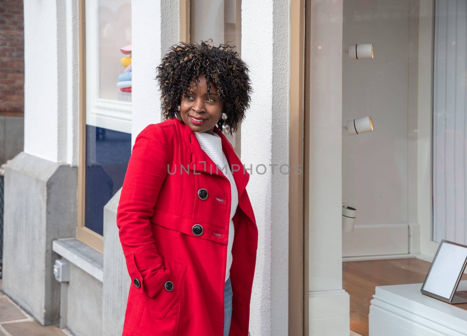 Happy confident smiling curvy african american woman with shopping bags standing on city street near shop windows. High quality photo