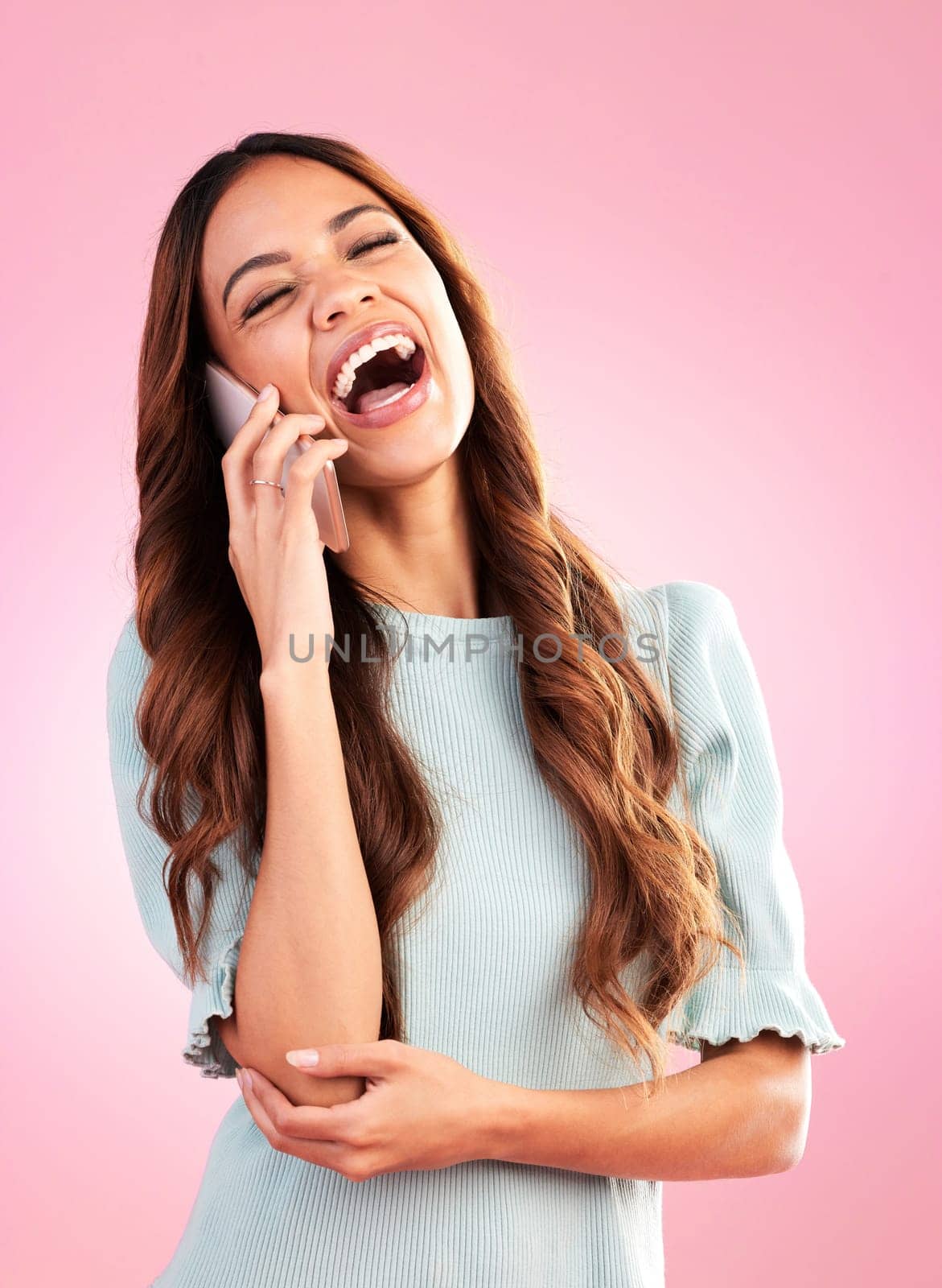 Woman, phone call and laugh with communication and technology, funny conversation on pink background. Happiness, young female with smile and connection with network, talking on mobile in studio by YuriArcurs