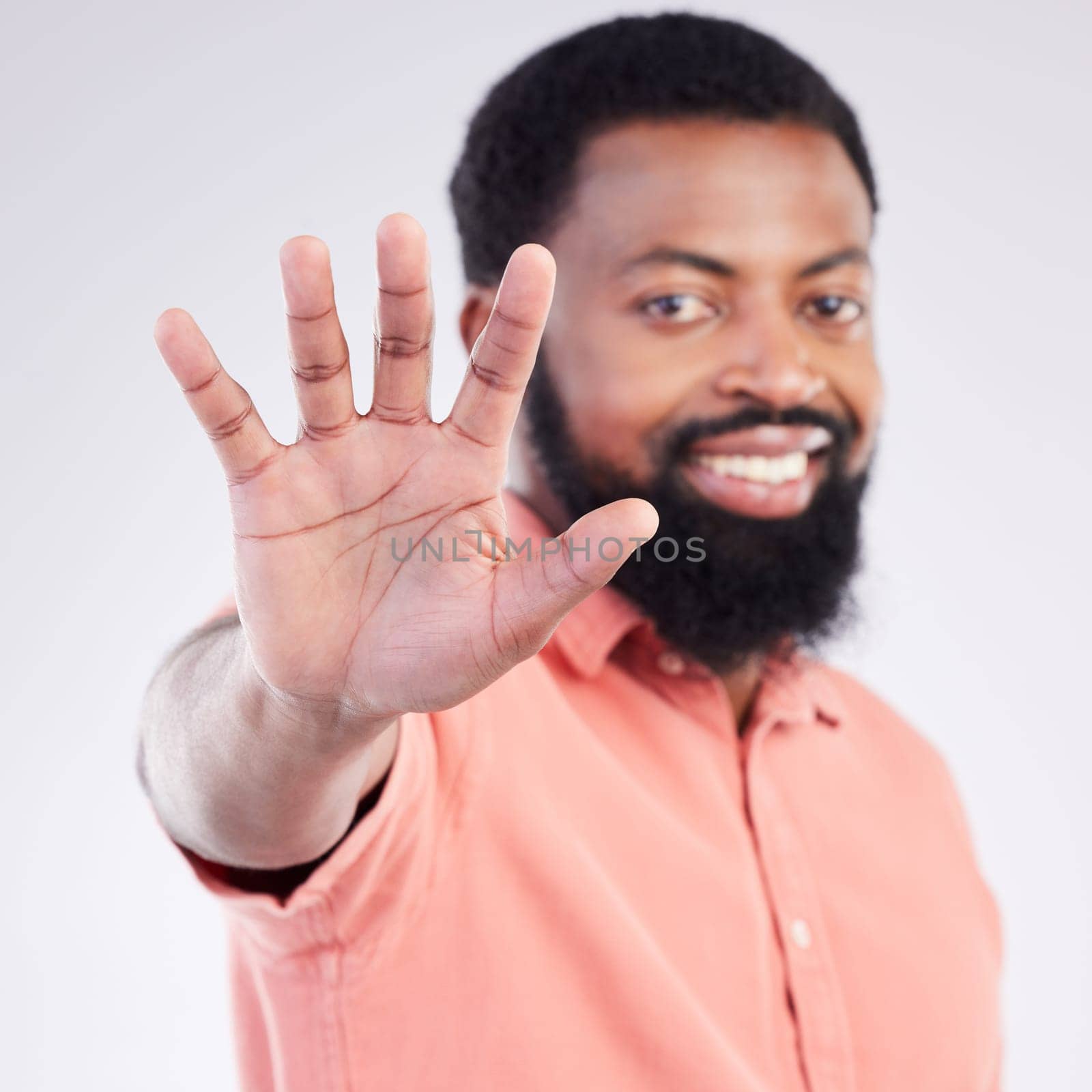 Black man, hand sign and stop in studio portrait with smile, icon and communication by background. Young african model, signal or symbol for opinion, protest palm and warning with confident choice by YuriArcurs