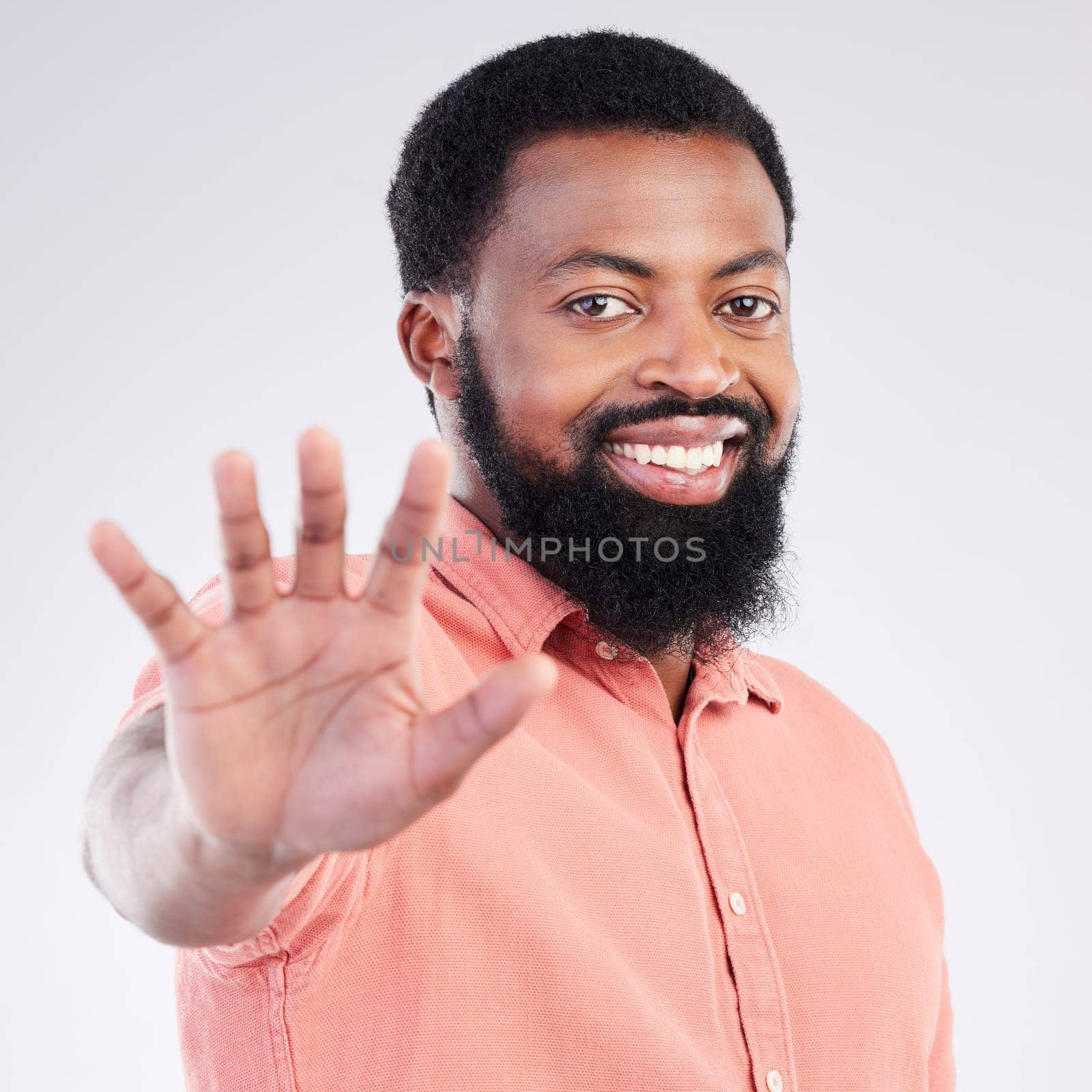 Black man, hand and stop in studio portrait with smile, sign language and communication by background. Young african model, signal or symbol for opinion, protest palm and voice with confident pride.