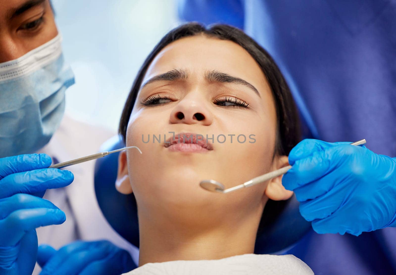 Is it too late to change my mind. a young woman experiencing anxiety while having a dental procedure performed on her. by YuriArcurs