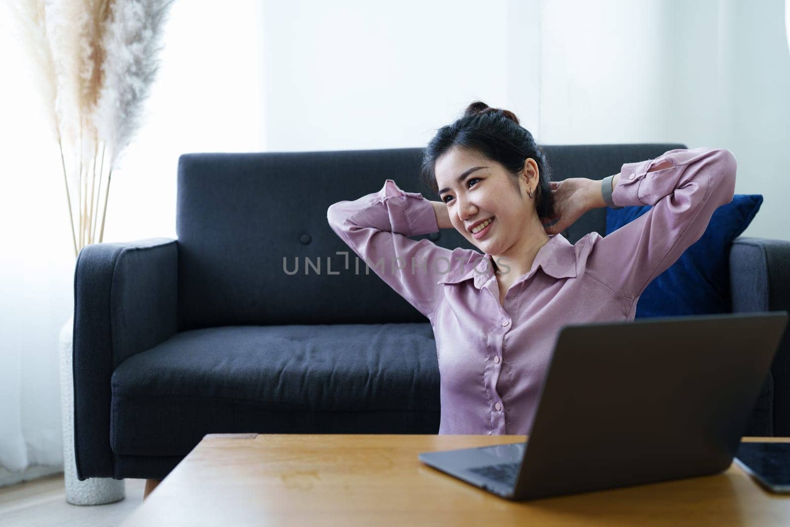 Portrait of a self-employed Asian woman using a computer at home.