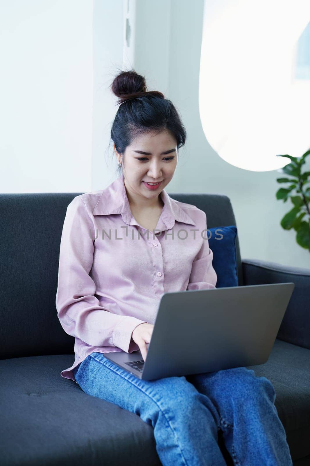Portrait of a self-employed Asian woman using a computer at home.