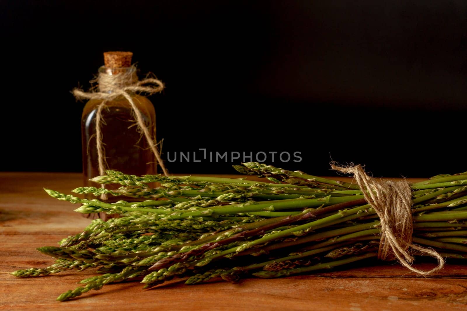 bunch of fresh wild asparagus with bottle of olive oil by joseantona