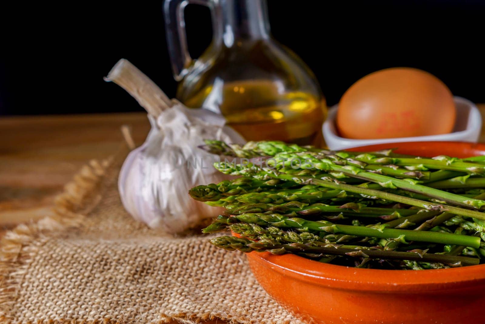 wild asparagus in an earthenware casserole dish by joseantona