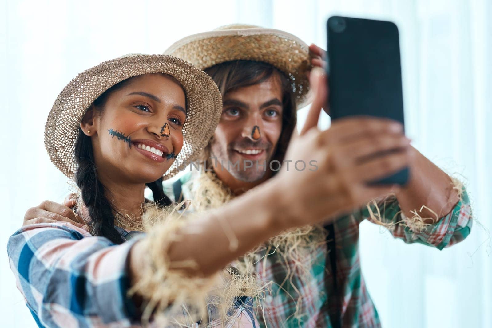 I think we look pretty good. a young couple taking a selfie at a party. by YuriArcurs