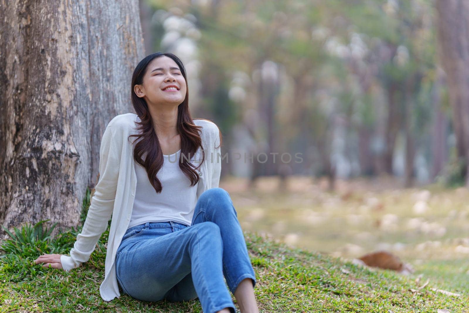 Cheerful overjoyed woman happy and enjoying peaceful beautiful in park, looking up with broad smile by itchaznong