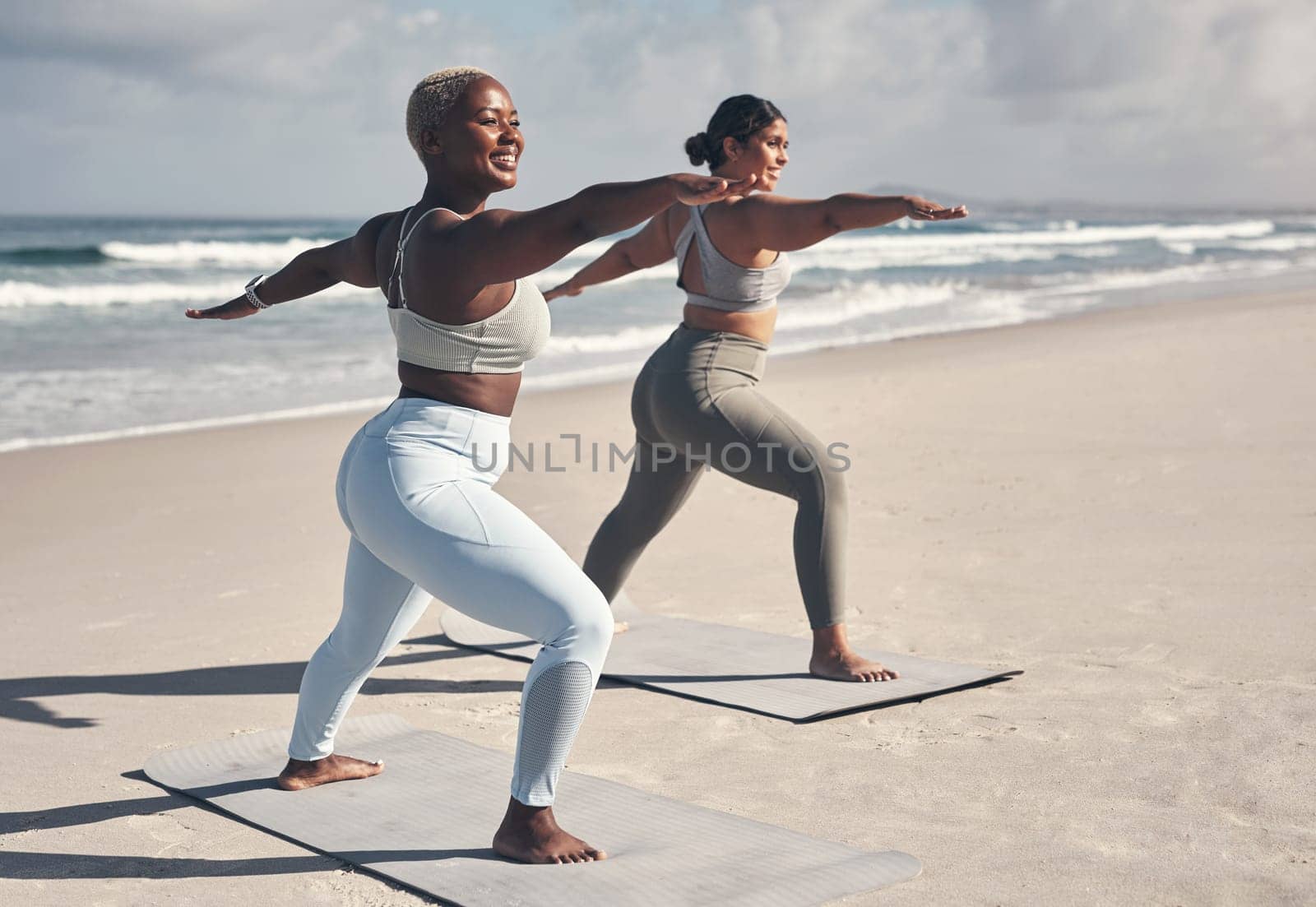 A bestie yoga session is always so much fun. two young women practicing yoga on the beach. by YuriArcurs
