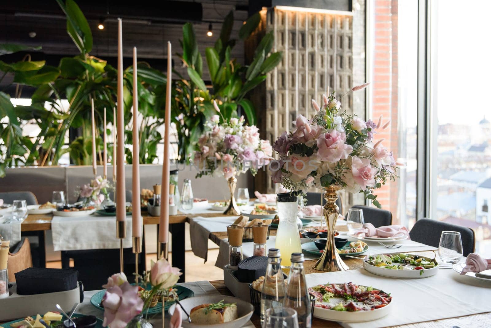 served table in the restaurant is decorated with a luxurious bouquet. Garden roses, eustoma, populus eucalyptus. pastel colours.