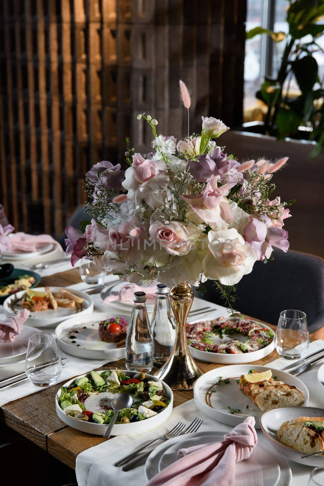 served table in the restaurant is decorated with a luxurious bouquet. Garden roses, eustoma, populus eucalyptus. pastel colours by Ashtray25