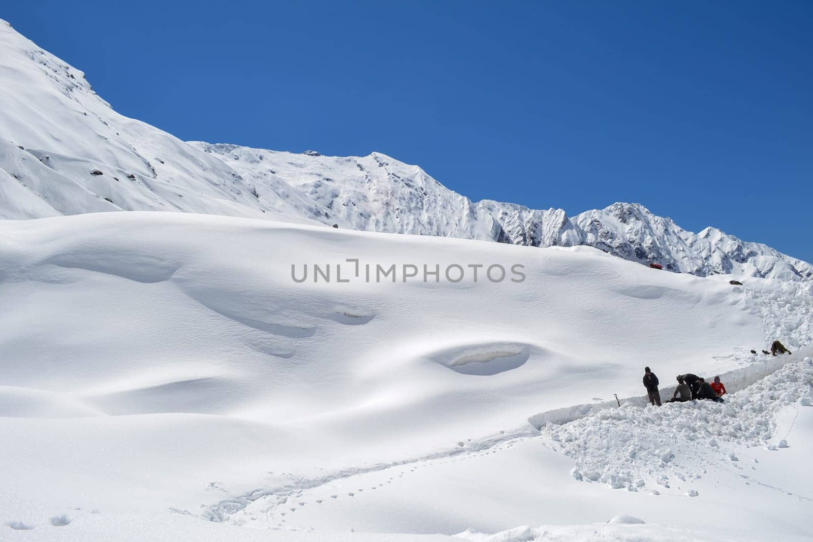 Laborer opening the snow-covered Kedarnath temple route by stocksvids