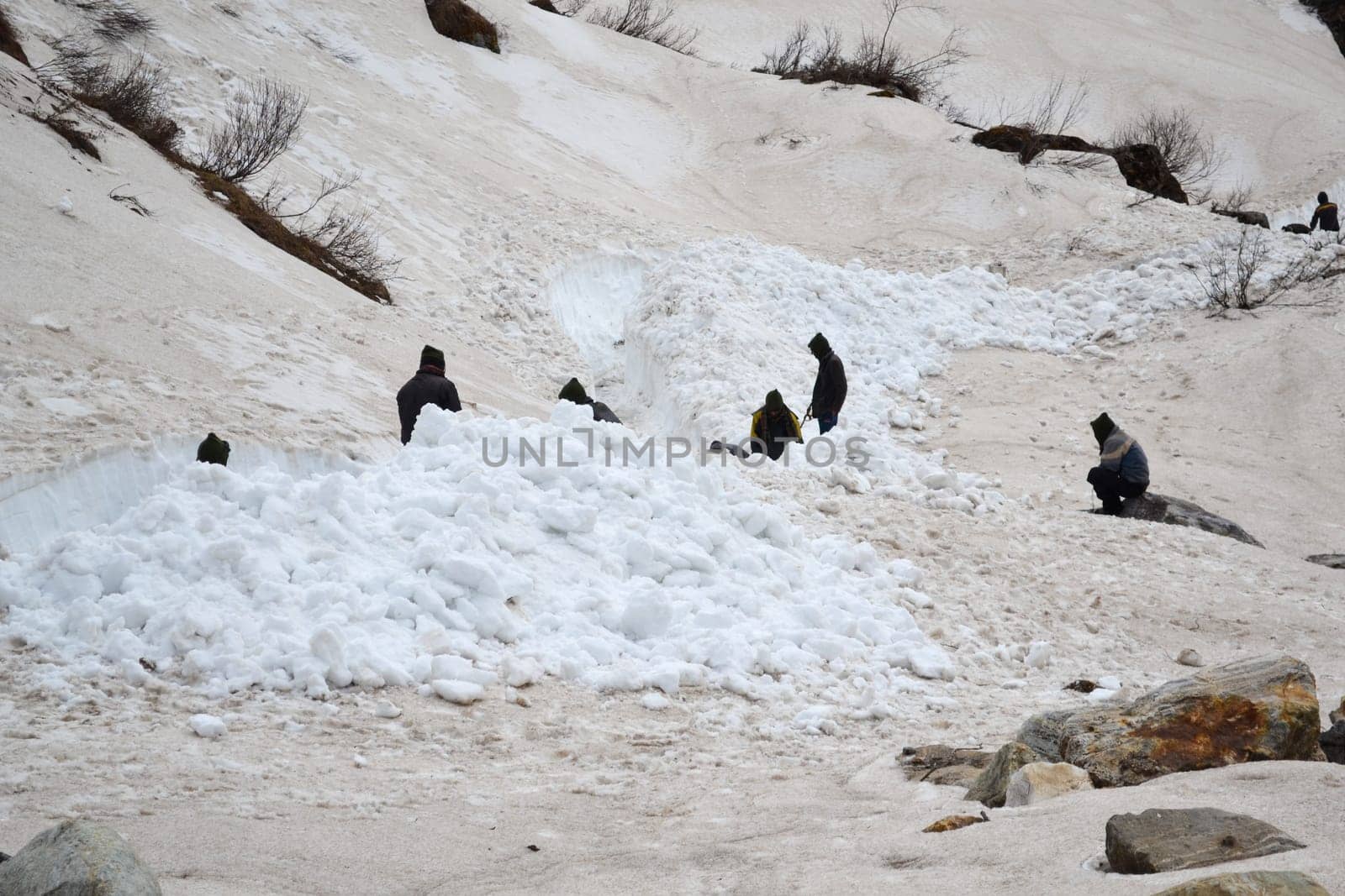 Laborer opening the snow-covered Kedarnath temple route by stocksvids