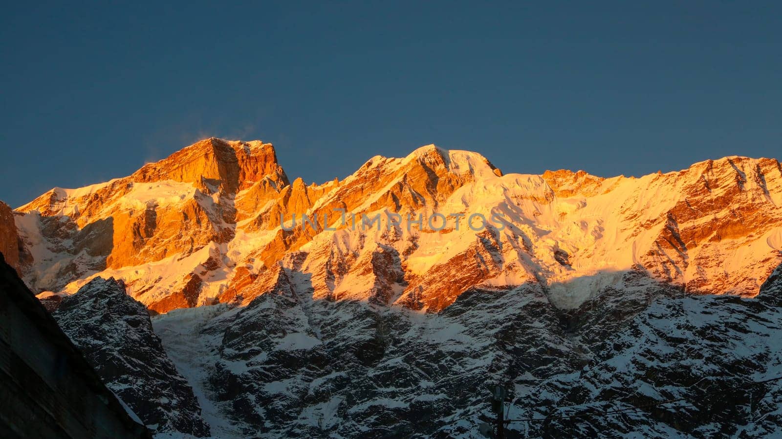 Snow covered mountain shining with the sun rays in Himalaya. by stocksvids