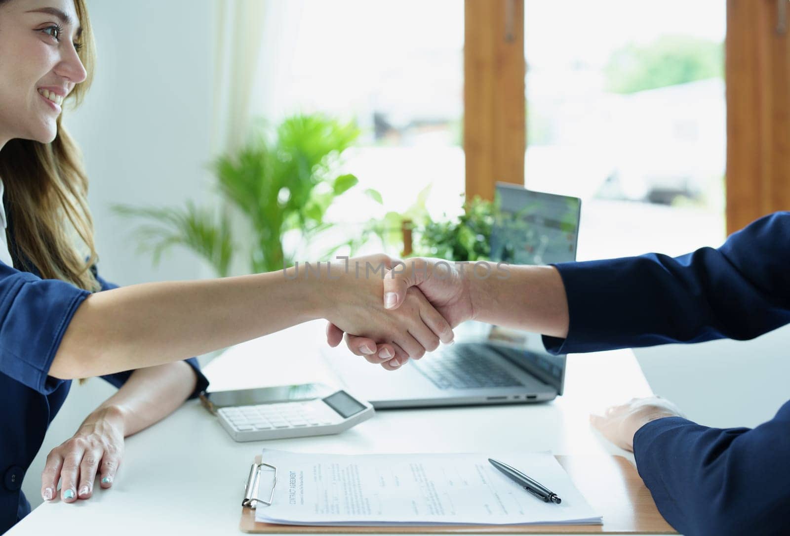 Asian entrepreneurs handshakes to congratulate the agreement between the two companies to enhance investment and financial strength. deal concept by Manastrong