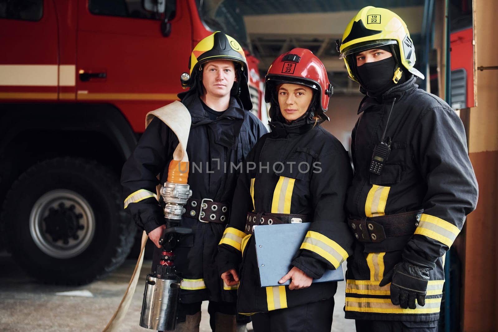 Posing for a camera. Group of firefighters in protective uniform that is on station.