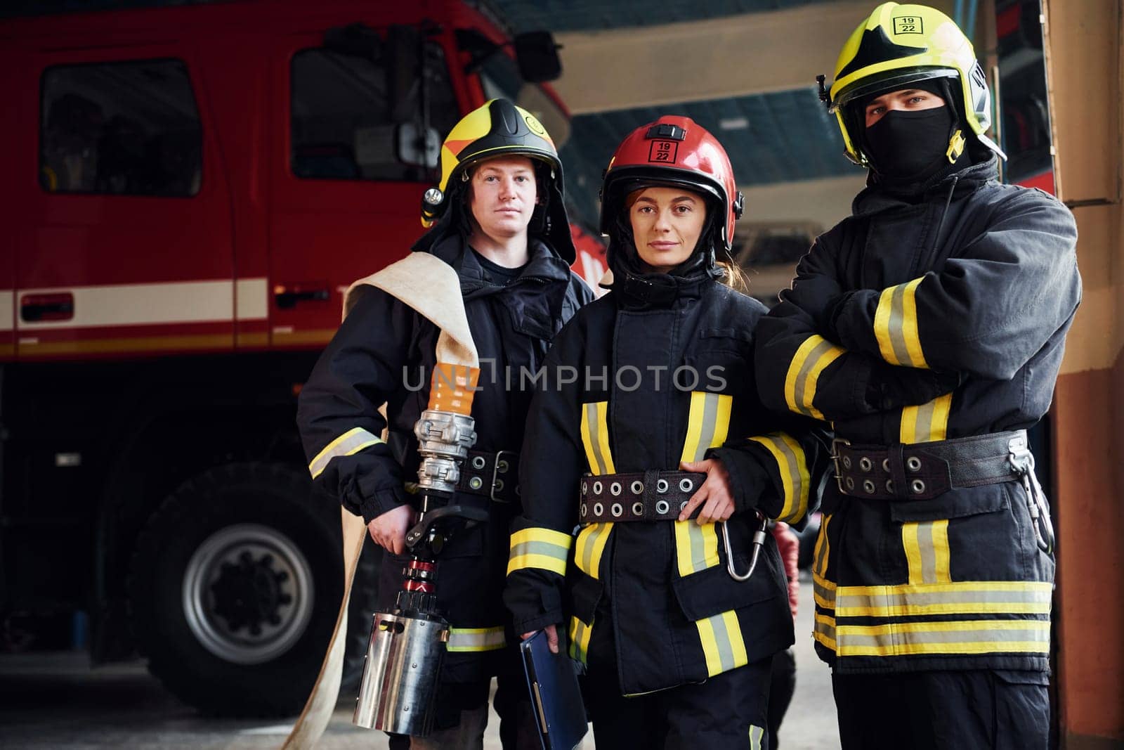 Posing for a camera. Group of firefighters in protective uniform that is on station.