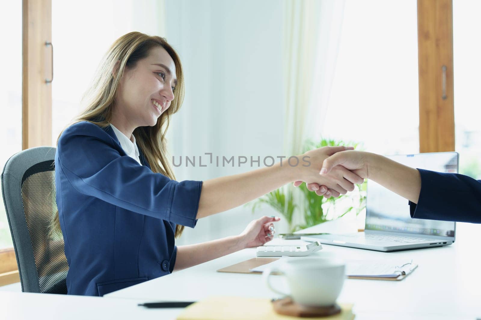 Asian entrepreneurs handshakes to congratulate the agreement between the two companies to enhance investment and financial strength. deal concept by Manastrong