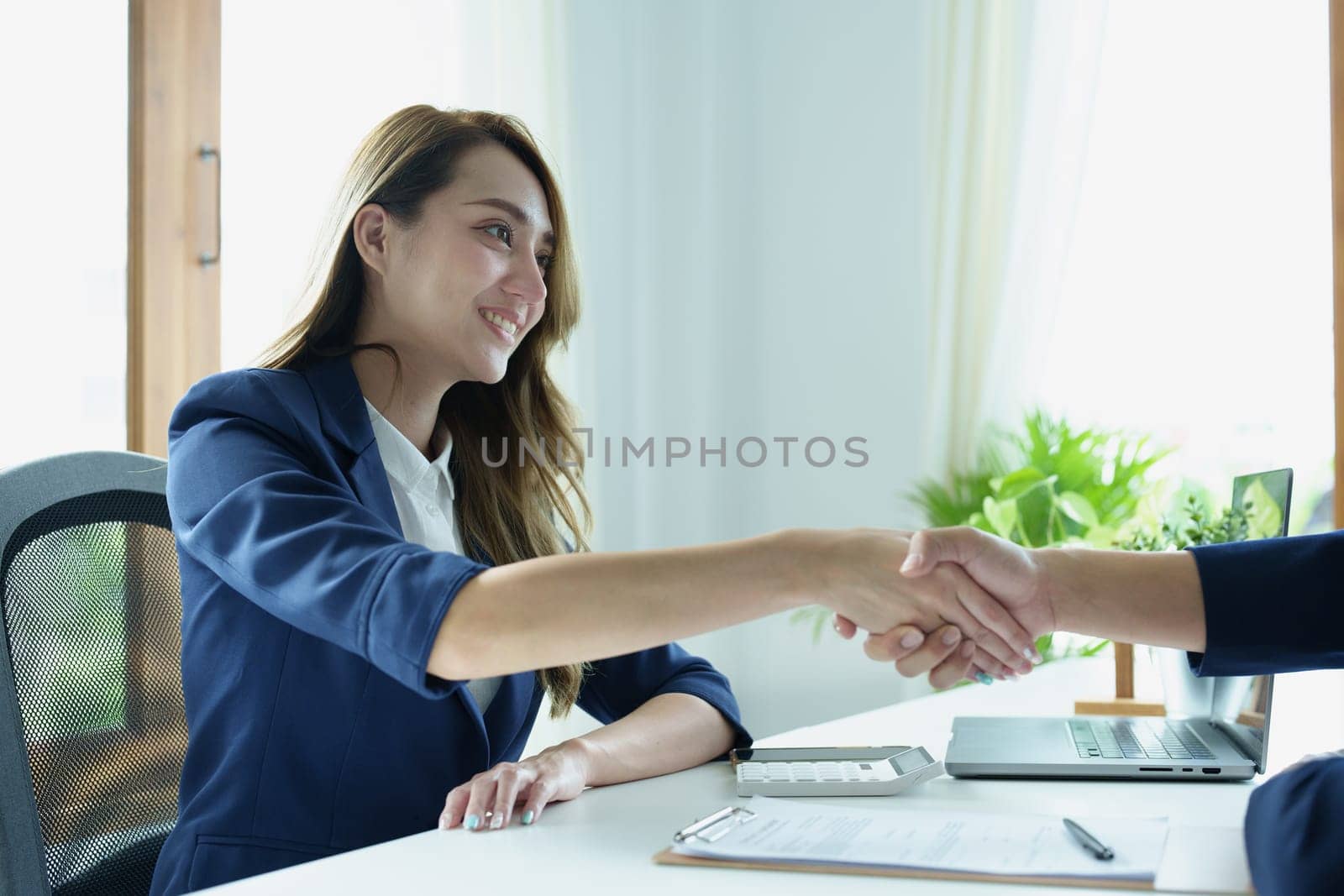 Asian entrepreneurs handshakes to congratulate the agreement between the two companies to enhance investment and financial strength. deal concept by Manastrong