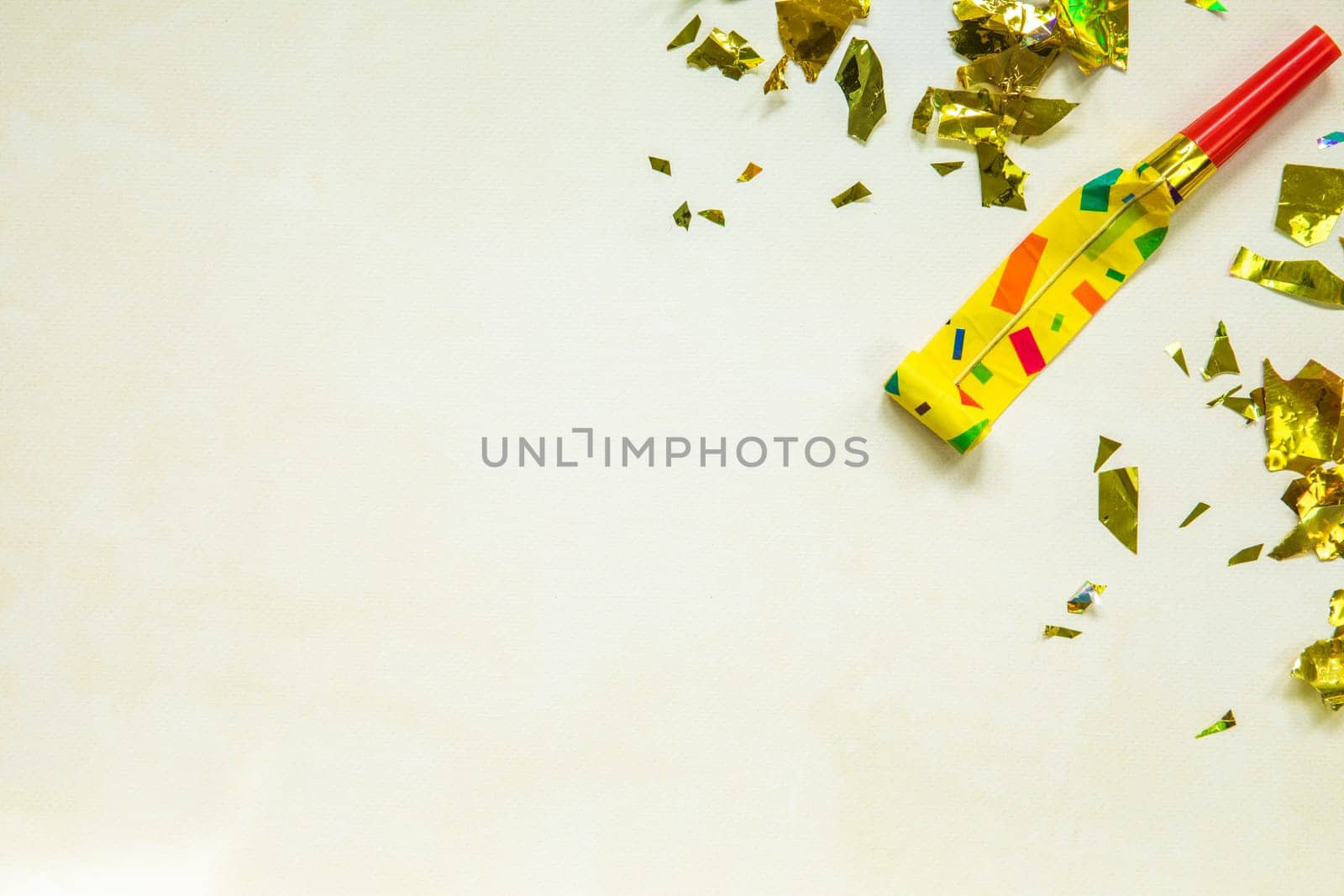 Birthday party blowouts whistles Rolled festive noisemaker or party whistle on concrete light background, blowing in whistle top view in and out loop 4k Happy Birthday copy space