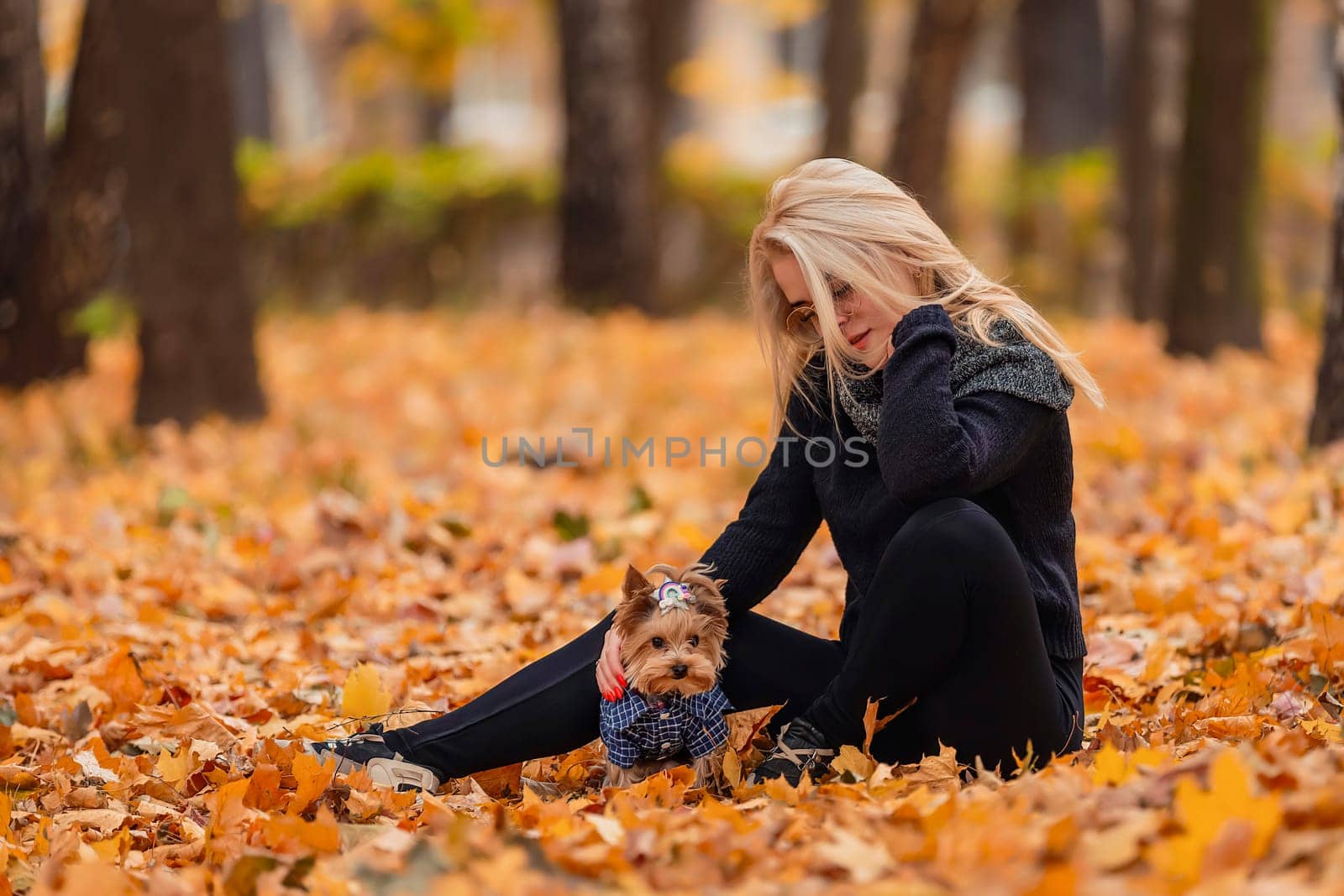 girl with her little dog in autumn park