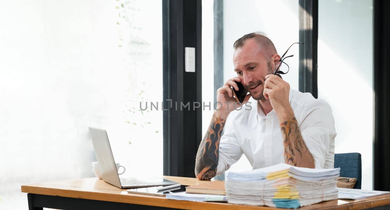 Happy business man with phone call while relaxing in the office.