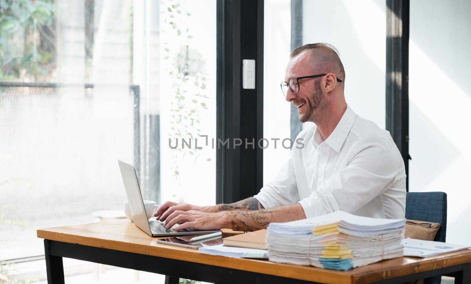 Businessman using laptop computer in office. Happy middle aged man, entrepreneur, small business owner working online..