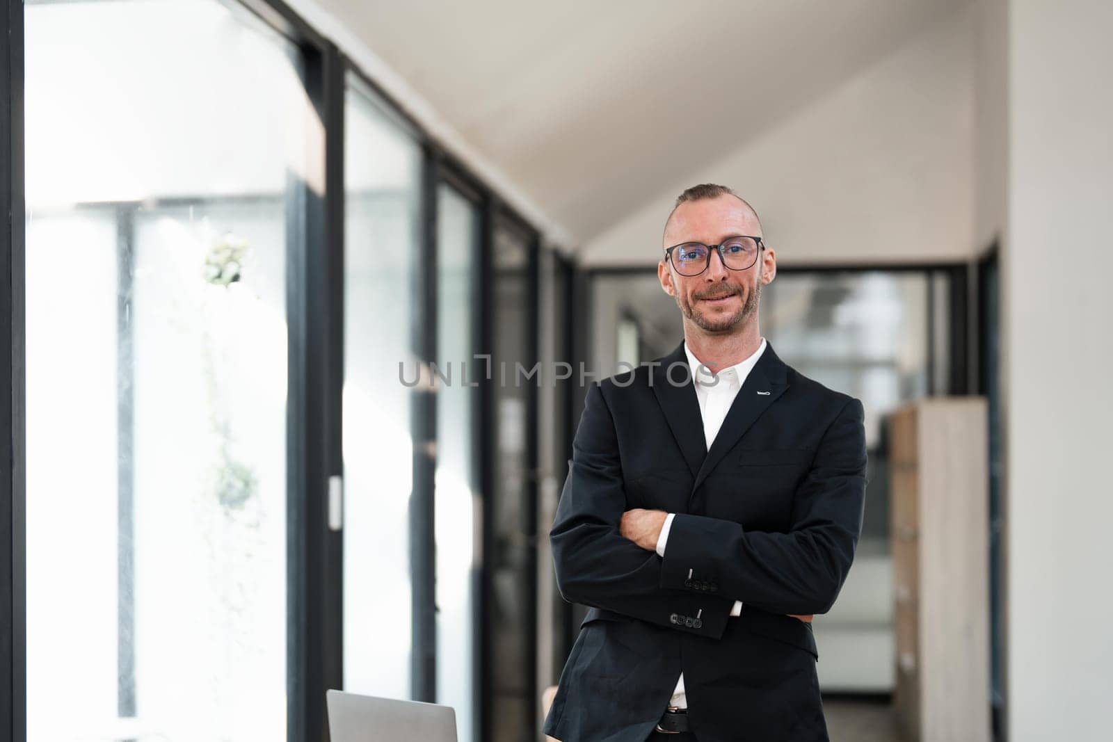 Portrait of successful business man, businessman in glasses and business suit looking at camera and smiling, businessman with crossed arms working office.