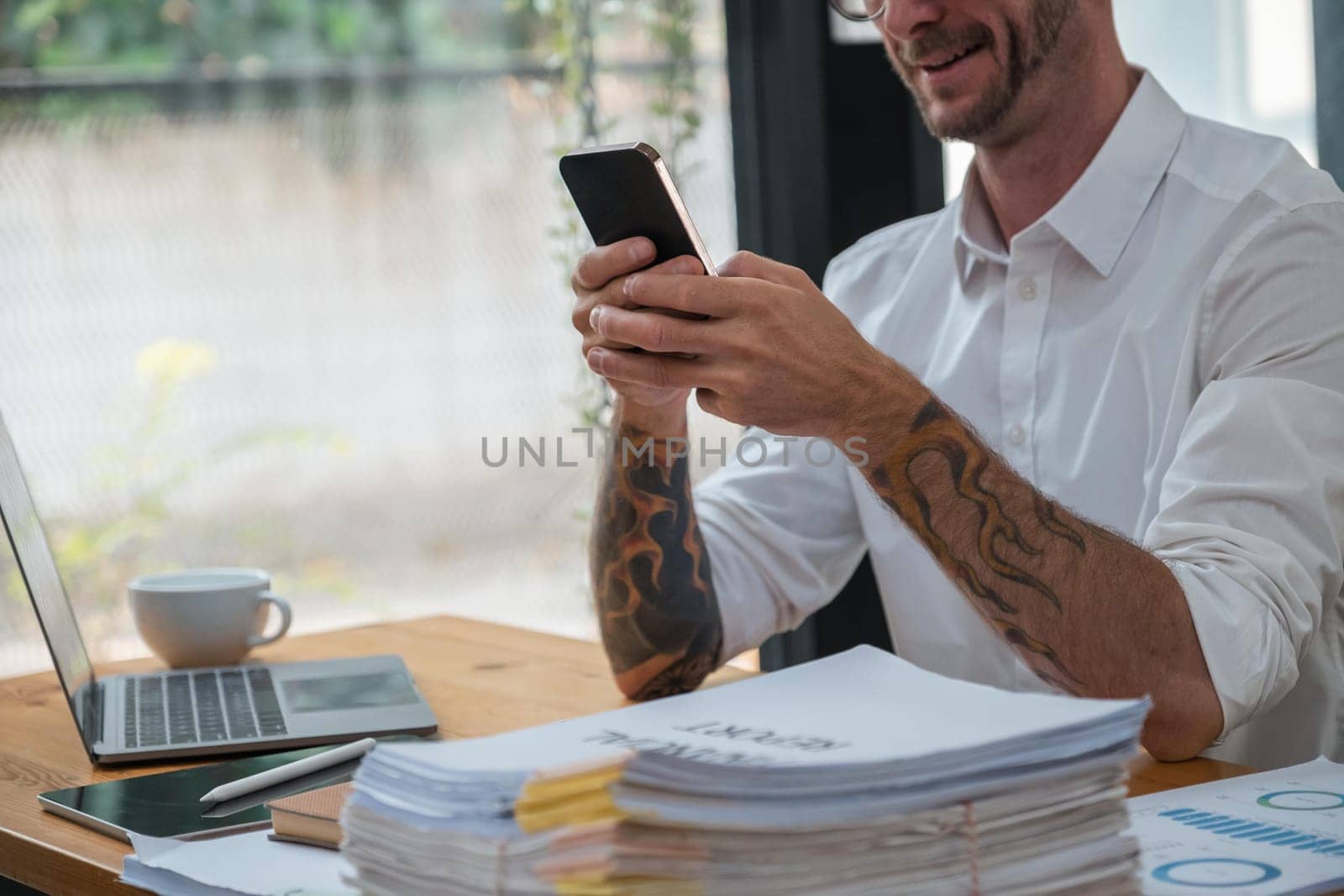 Portrait of a cheerful man using smart phone at home office..