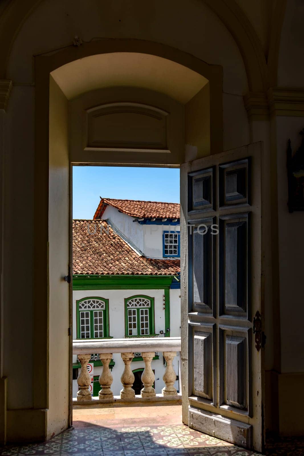 Antique colonial houses seen through the door of historic church in the city of Diamantina in Minas Gerais