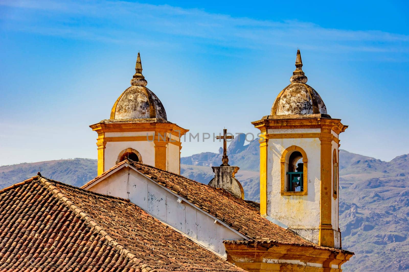 Back view of old and historic church in colonial architecture from the 18th century in the city of Ouro Preto in Minas Gerais, Brazil  with mountains and hills behind