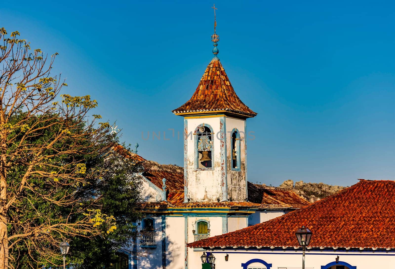 Baroque church bell tower with rising through the trees and roofs of the historic town of Diamantina in Minas Gerais, Brazil