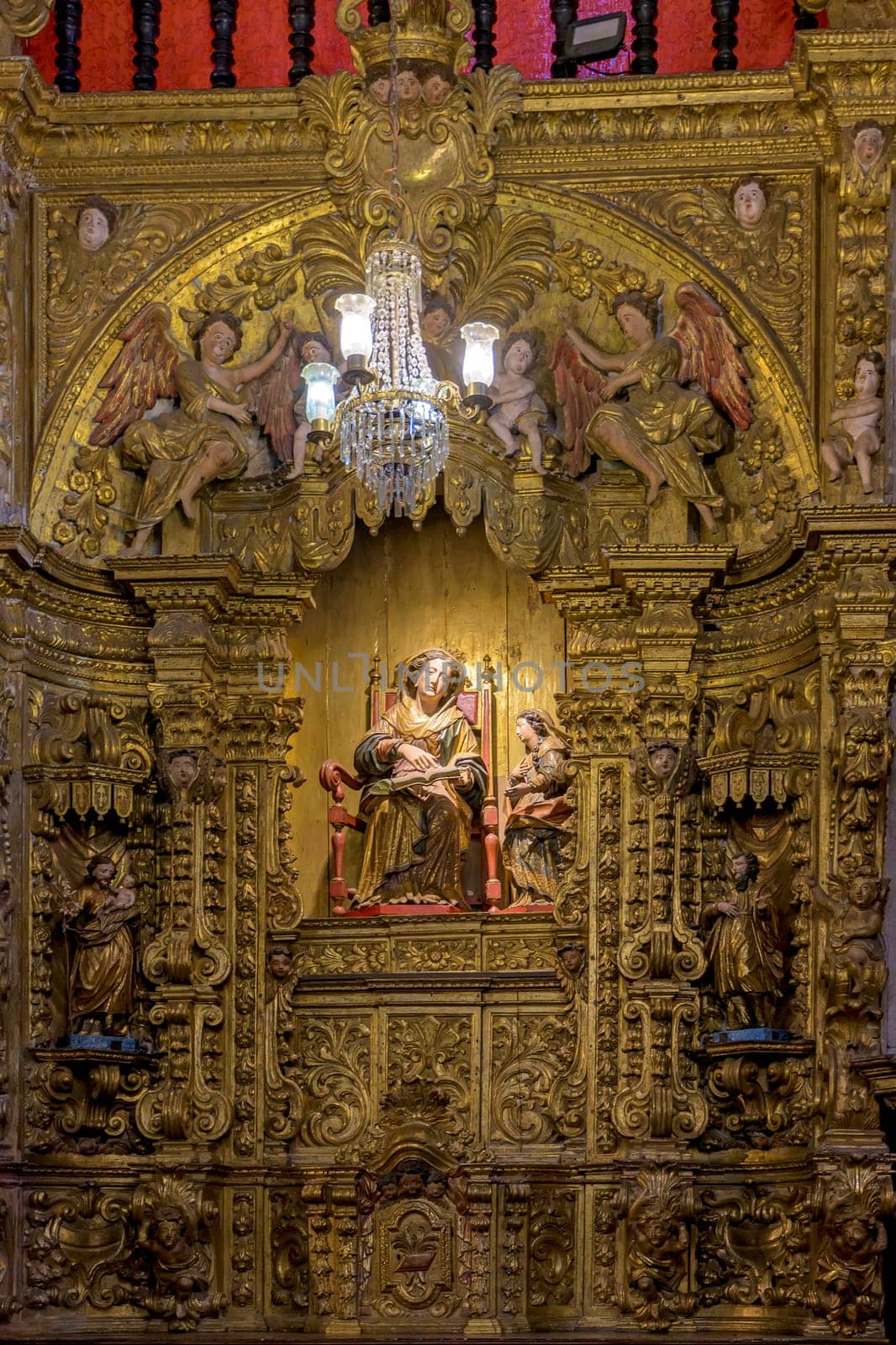 Interior of a baroque church decorated with images of saints and walls with gold leaf ornaments in the historic city of Ouro Preto, Minas Gerais