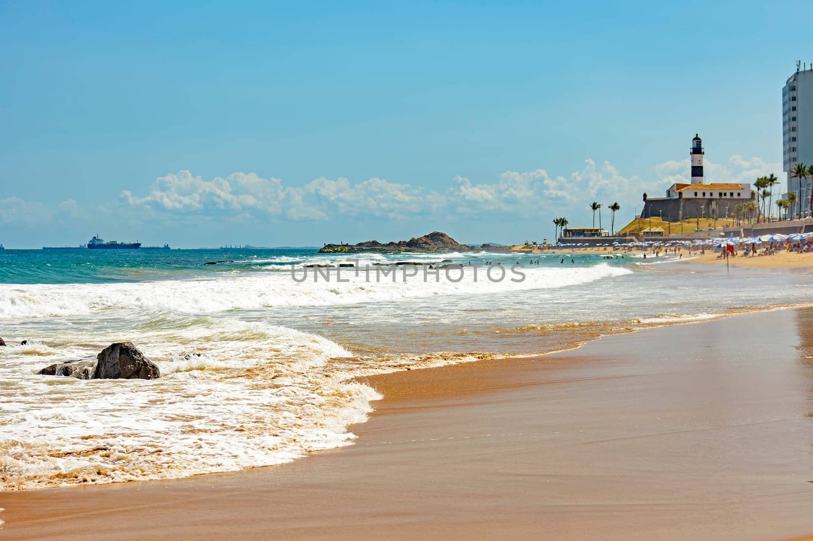 Barra beach buildings and lighthouse seen from afar with the summer sun of Salvador in Bahia